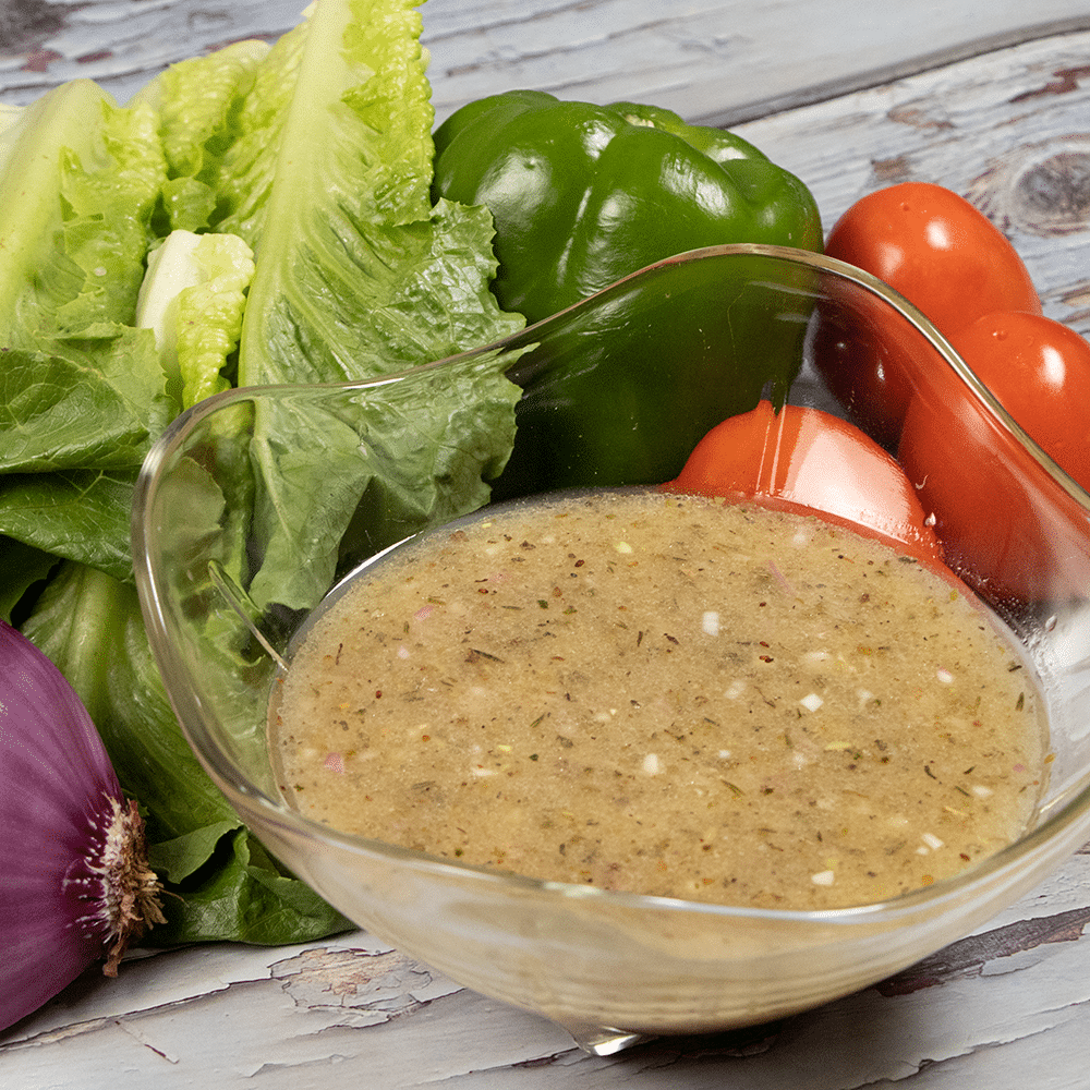 Gluten-free dairy-free Italian vinaigrette dressing in a clear pouring bowl